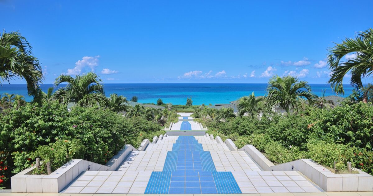 南国の植物に囲まれた青い海へ続く遊歩道