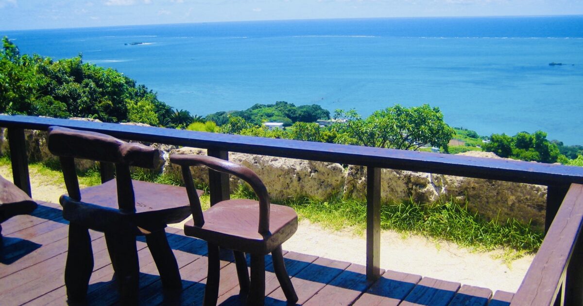 木製テラスから見渡す青い海と緑の風景