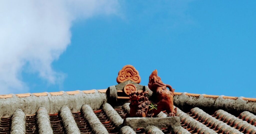 赤瓦屋根の上に並ぶシーサーと青空
