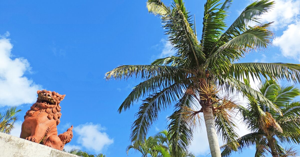 シーサーとヤシの木が並ぶ南国の風景
