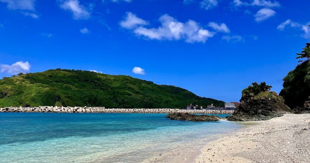 透明度の高い海と緑の山に囲まれた静かなビーチ