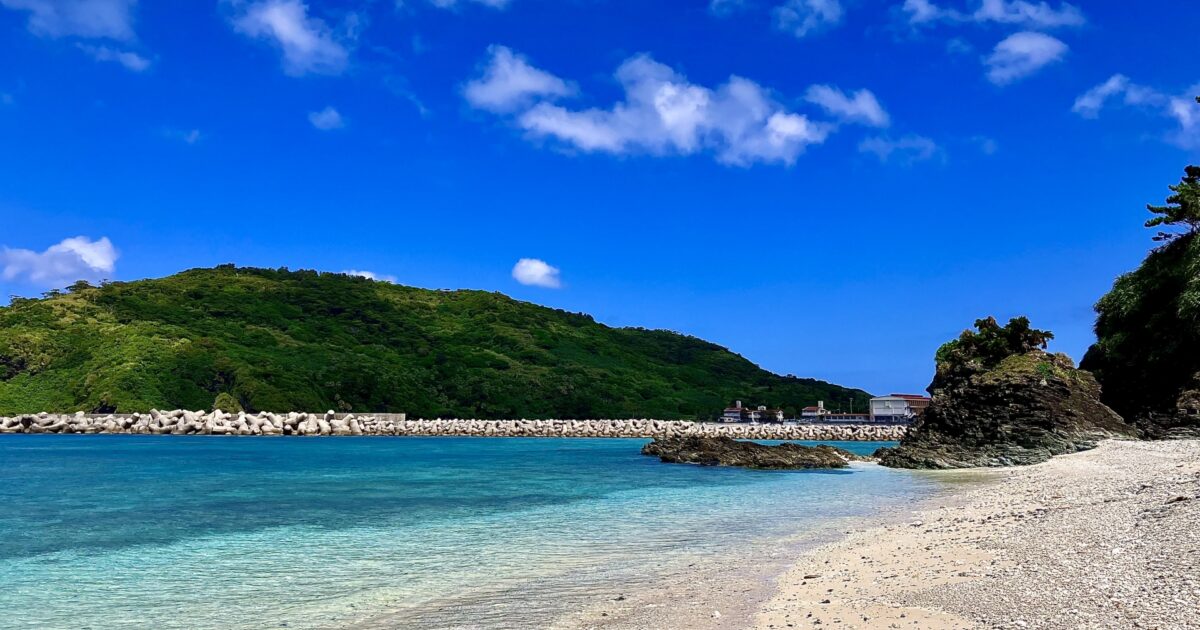 透明度の高い海と緑の山に囲まれた静かなビーチ