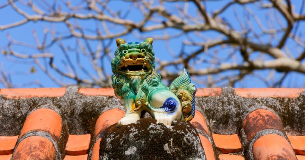 赤瓦屋根の上にあるカラフルなシーサーの置物